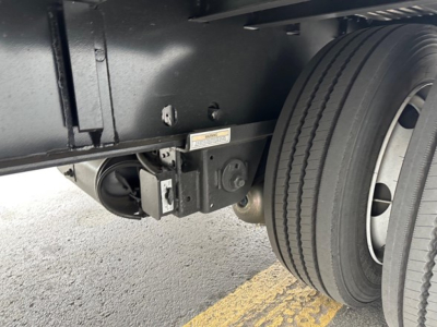 New utility trailer with drop deck and dual rear wheels showing hitch area and tire tread.