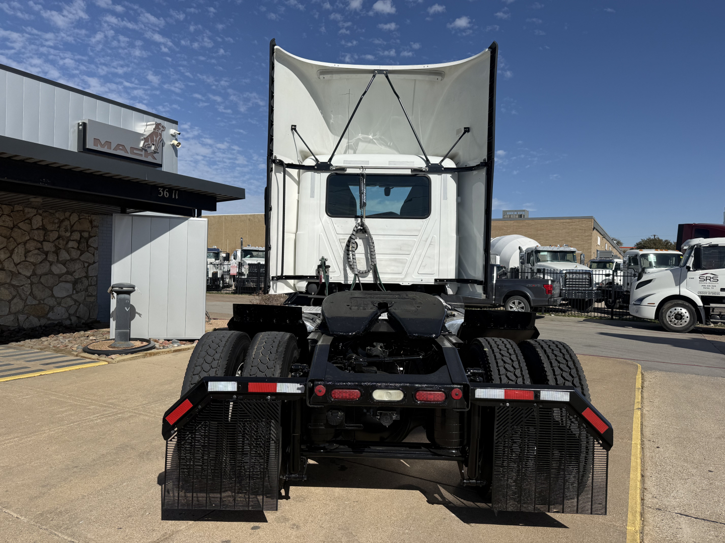 Truck rear view showing fifth wheel and dual wheel dual-axle setup of a 2022 Mack AN42T conventional daycab with white cab and trailer hitch area visible.