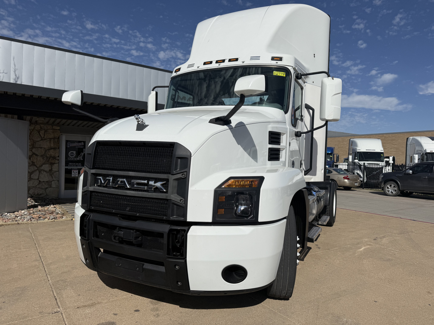 Mack AN42T conventional daycab truck front view showing Mack grille, headlights, and white cab with large mirrors.