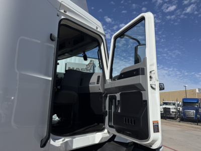 Truck cab interior visible through open door showing Mack AN42T dash area and door panel.