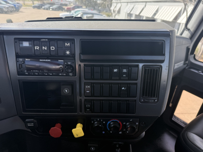 Mack AN42T truck dashboard with gear indicator, radio, and control panels visible; various switches and knobs, dual air vent, windshield view.