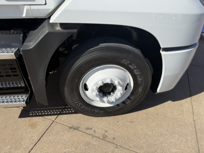 Truck wheel and fender close-up showing front tire with rim on a Mack AN42T conventional daycab.