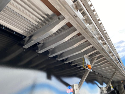 Flatbed trailer undercarriage and support beams of a 2024 Utility 4000Ae trailer showing structural beams and side rails.
