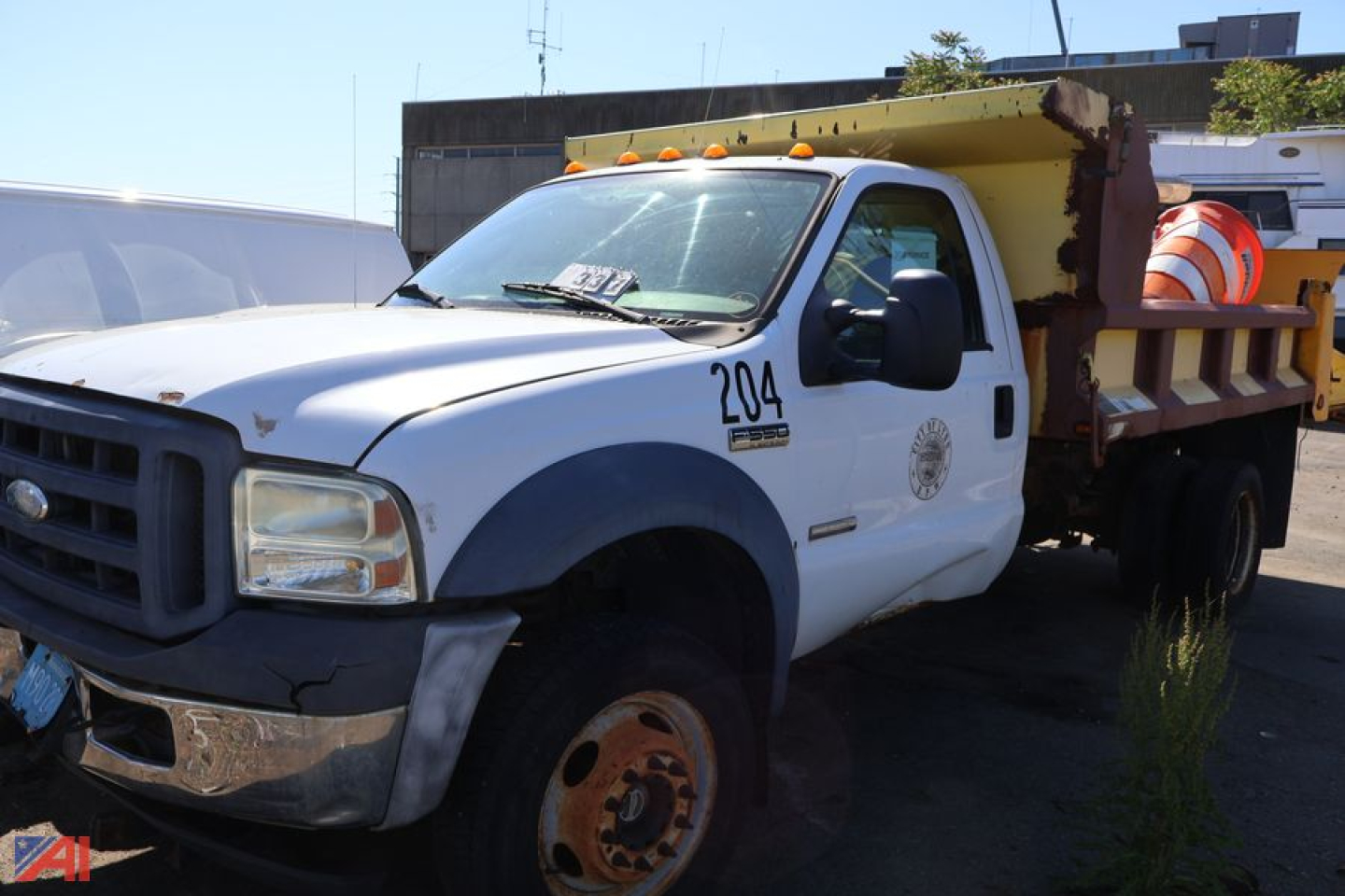 1996 Ford F-550 dump truck front-left view showing orange safety beacon and truck bed with steel sides