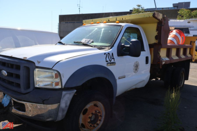 1996 Ford F-550 dump truck front-left view showing orange safety beacon and truck bed with steel sides