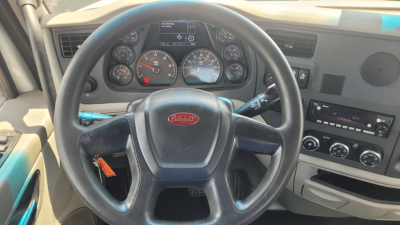 Peterbilt truck dashboard with steering wheel and instrument cluster visible inside cab.