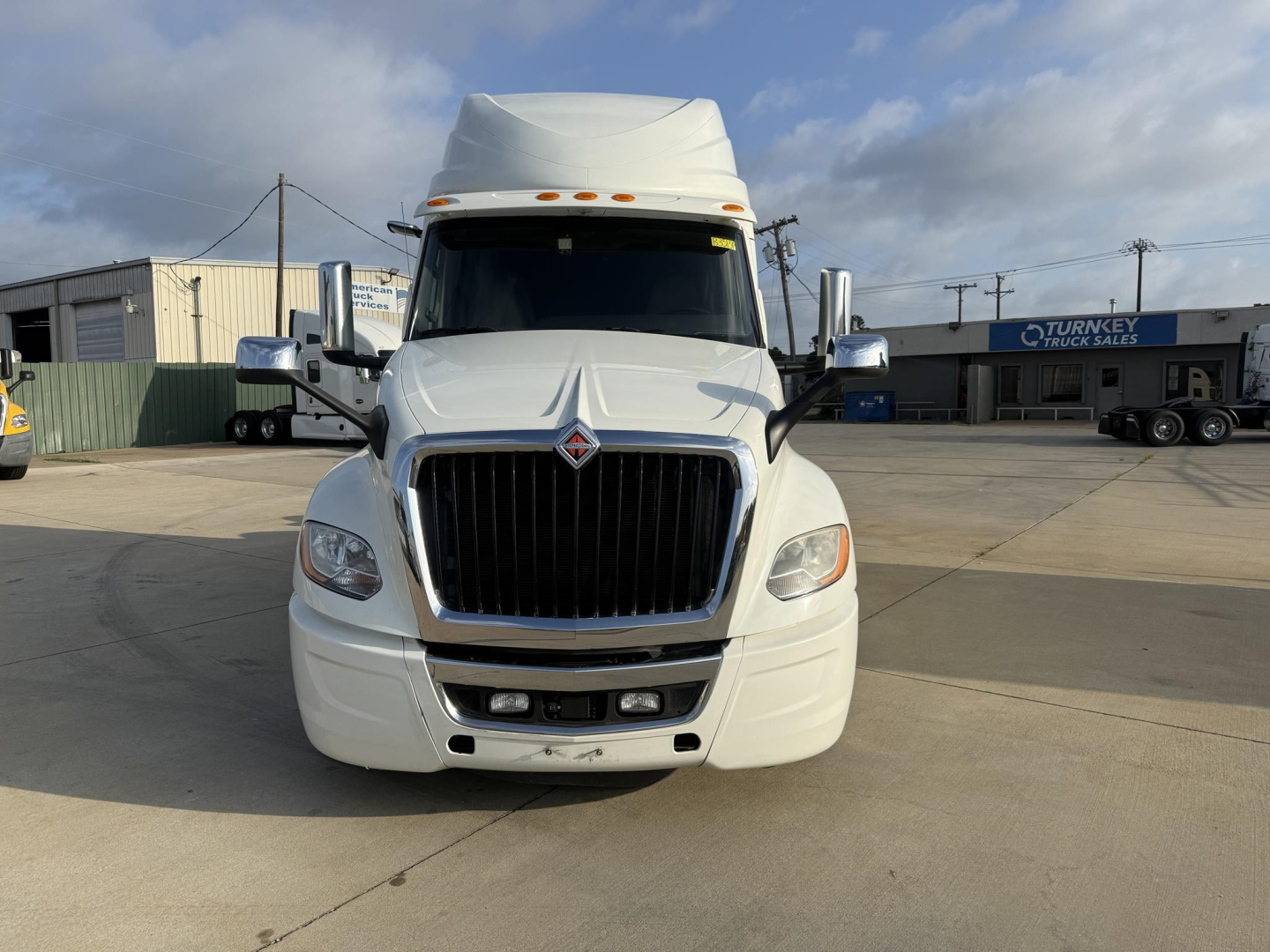 Truck front view showing International LT sleeper cab with prominent grille and headlights. No visible text on the vehicle surfaces.