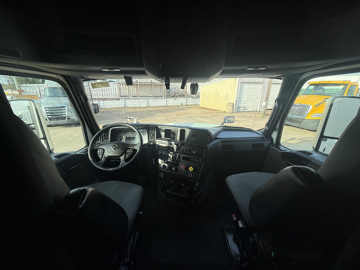 Interior cab view of a 2020 International LT truck showing steering wheel, dashboard, center console, and driver/passenger seats.
