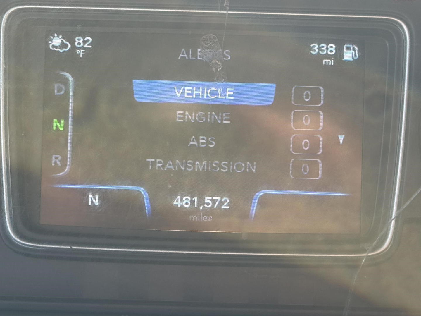 Vehicle instrument cluster display showing Vehicle menu with mileage 481,572 miles, ambient 82°F, 338 miles range, gears D N R, and various 0s for Engine, ABS, Transmission readings.