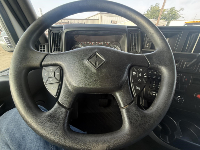 steering wheel with International logo in center showing controls on left and right and dashboard behind
