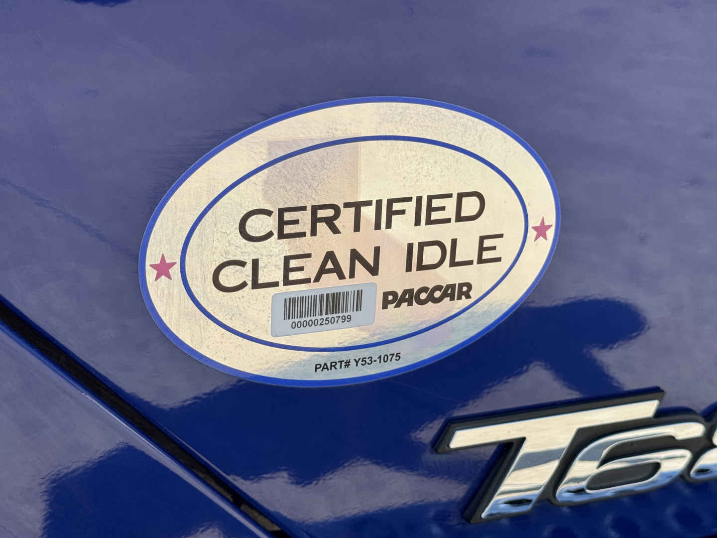 Sticker on blue Kenworth T680 showing Certified Clean Idle PACCAR emblem.