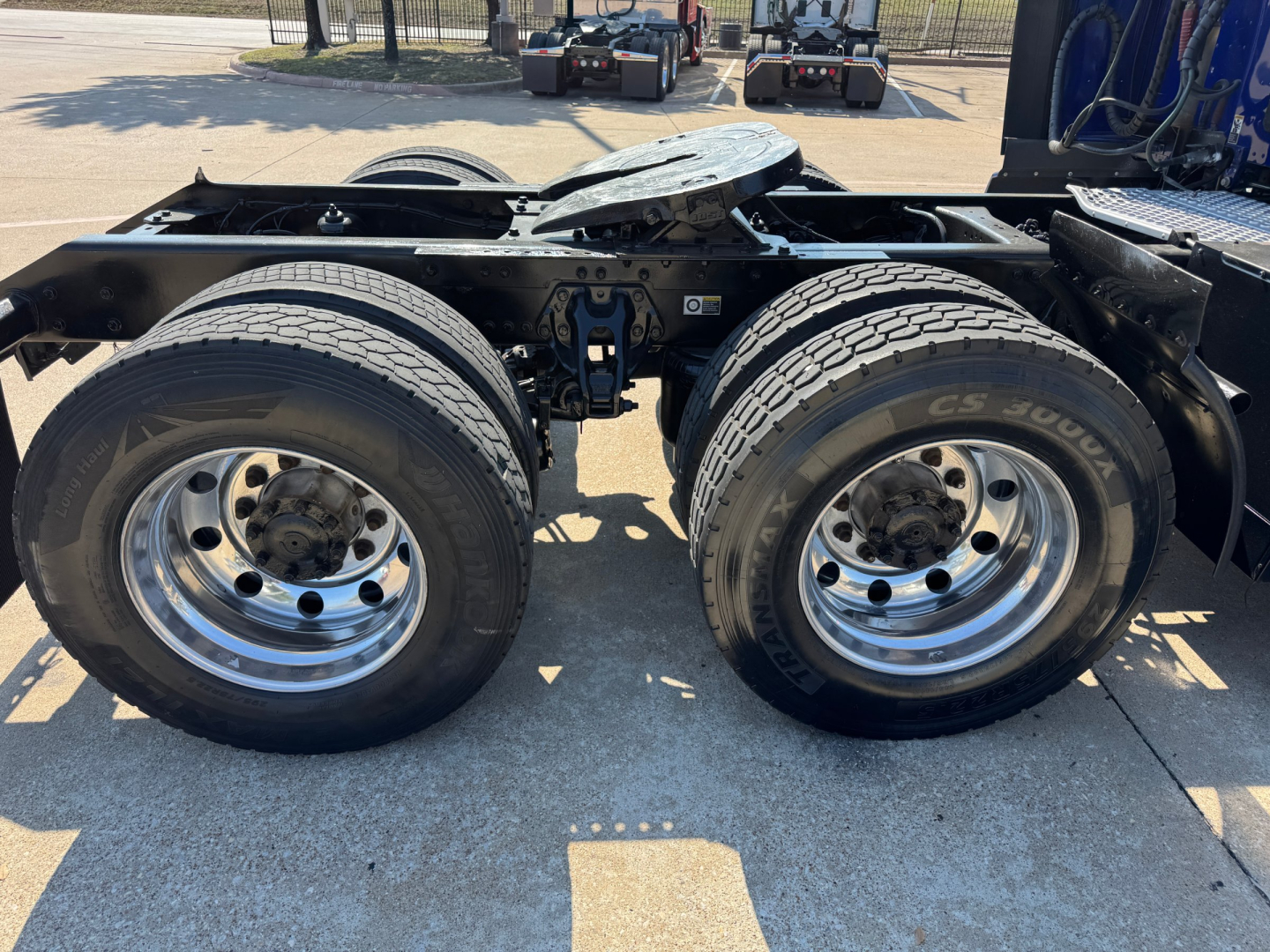 Kenworth T680 trailer-axle area showing dual rear wheels and chassis frame with fifth wheel plate.
