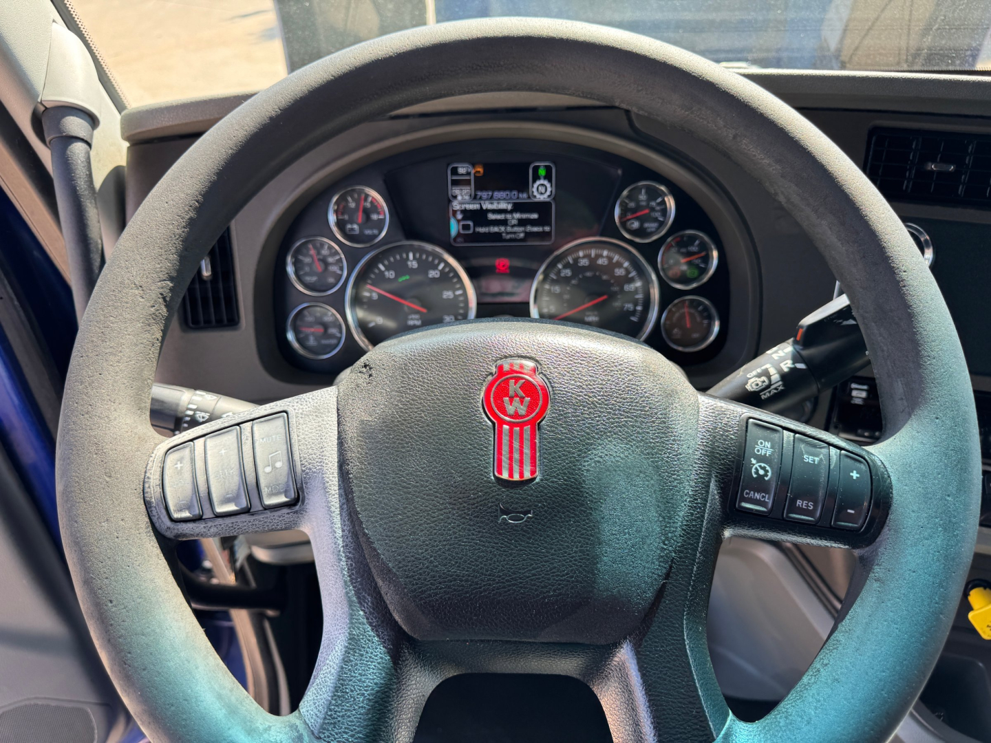 Kenworth T680 steering wheel and dashboard view showing gauges and controls.