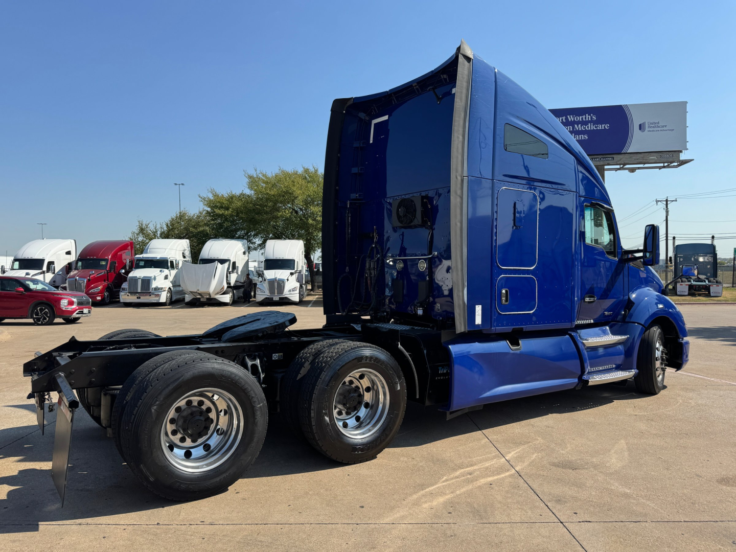 Kenworth T680 tractor truck side/back view showing blue exterior and dual rear axles with cab sleeper, no visible text or labels readable.