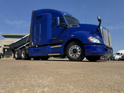 Truck image: blue 2019 Kenworth T680 conventional sleeper, side-front view, wheel and fuel tank visible.