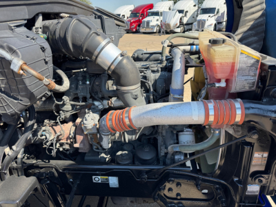 Kenworth T680 engine bay showing air intake hose, coolant reservoir, and various hoses and components.