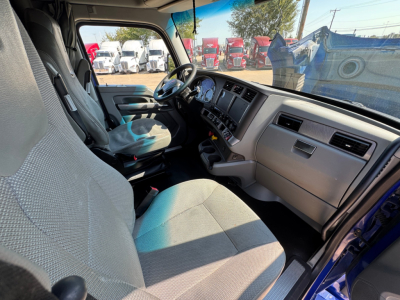 Kenworth T680 interior cab view showing steering wheel, dashboard, and front seats.