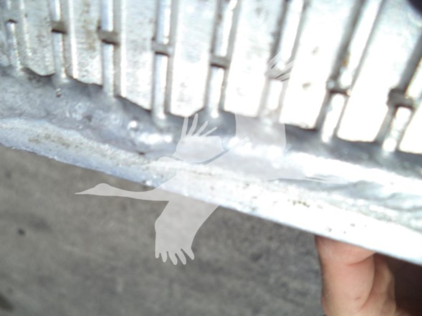 Image shows a portion of a truck tire and undercarriage with a light watermark of birds. No legible labels or text visible.