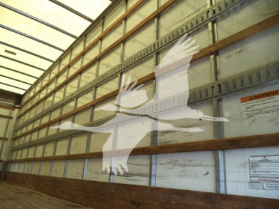 Image of an interior view of a truck trailer with a large white logo of a flying bird on the side; no vehicle details visible.