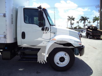 International MV truck side view showing cab and front wheel with white body and cargo box