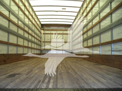 Trucks cargo trailer interior showing empty box area with wooden floor and aluminum side walls, silhouette watermark of a bird in flight center.