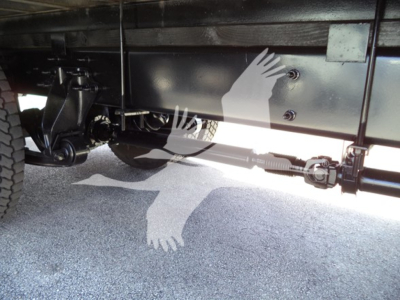 Truck undercarriage showing drivetrain components and axle bars.