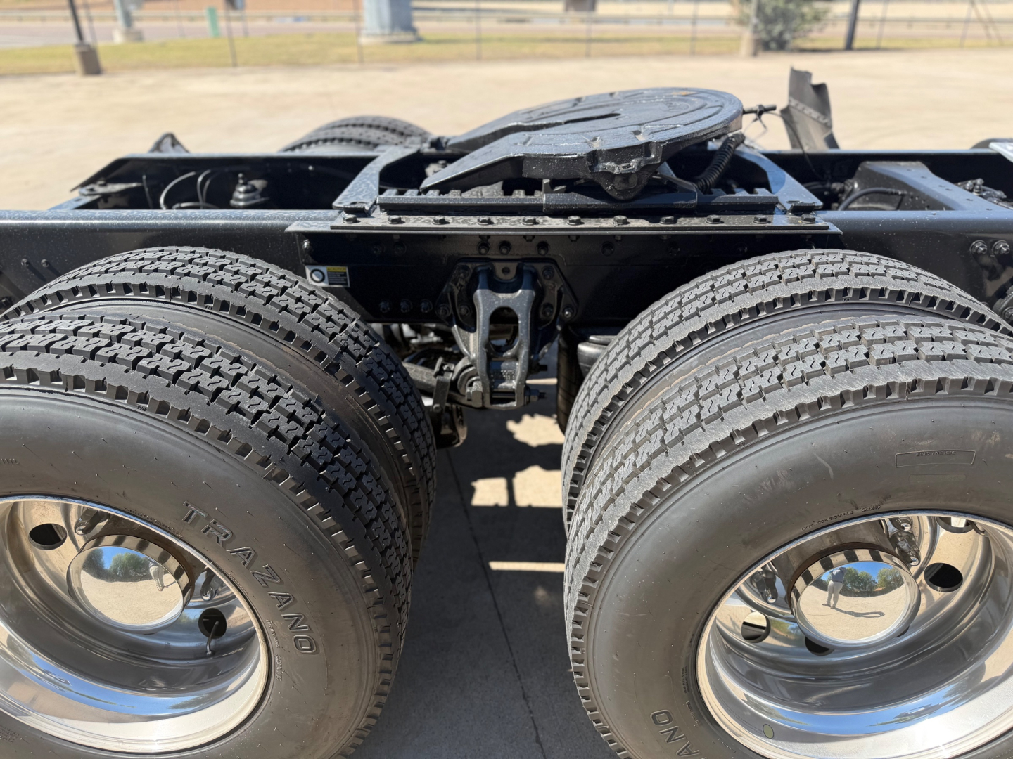 Kenworth T880 chassis with dual rear axles and fifth wheel, view of rear bogie and drivetrain components.
