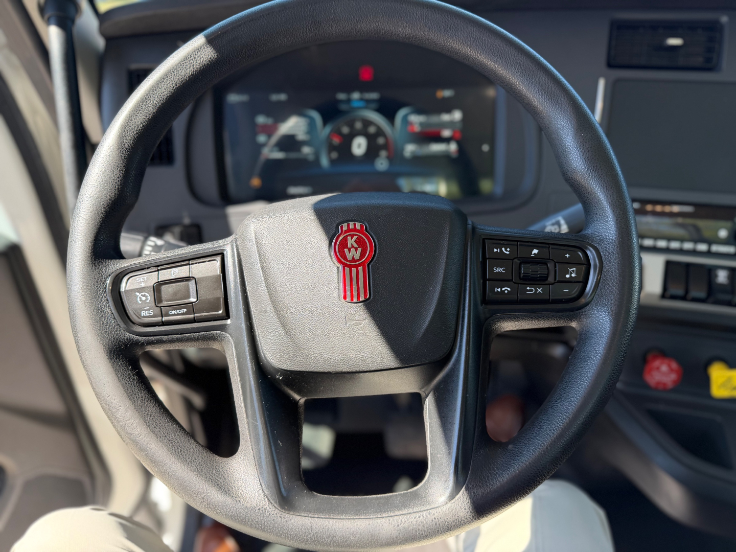 Kenworth T880 steering wheel and cockpit view showing digital gauge cluster and steering controls.