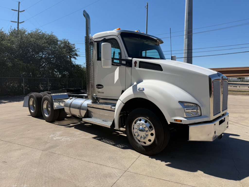 Kenworth T880 conventional daycab truck side view showing cab, fuel tanks, and dual rear axles.