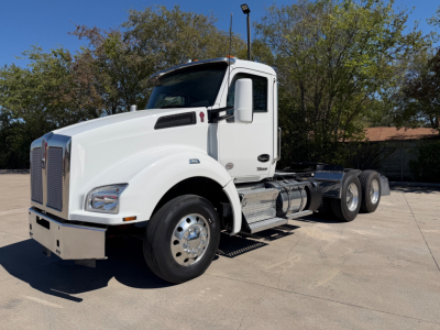 Kenworth T880 daycab tractor showing front and side with white paint and dual rear axle configuration.