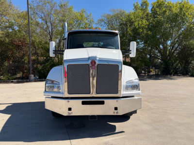 Kenworth T880 conventional daycab front view showing large chrome grille, dual rectangular headlights, and wide bumper.