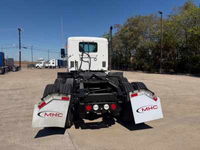 Kenworth T880 tractor rear view showing mud flaps with MHC logos and fifth wheel area.