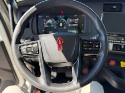 Kenworth T880 steering wheel and cockpit view showing digital gauge cluster and steering controls.