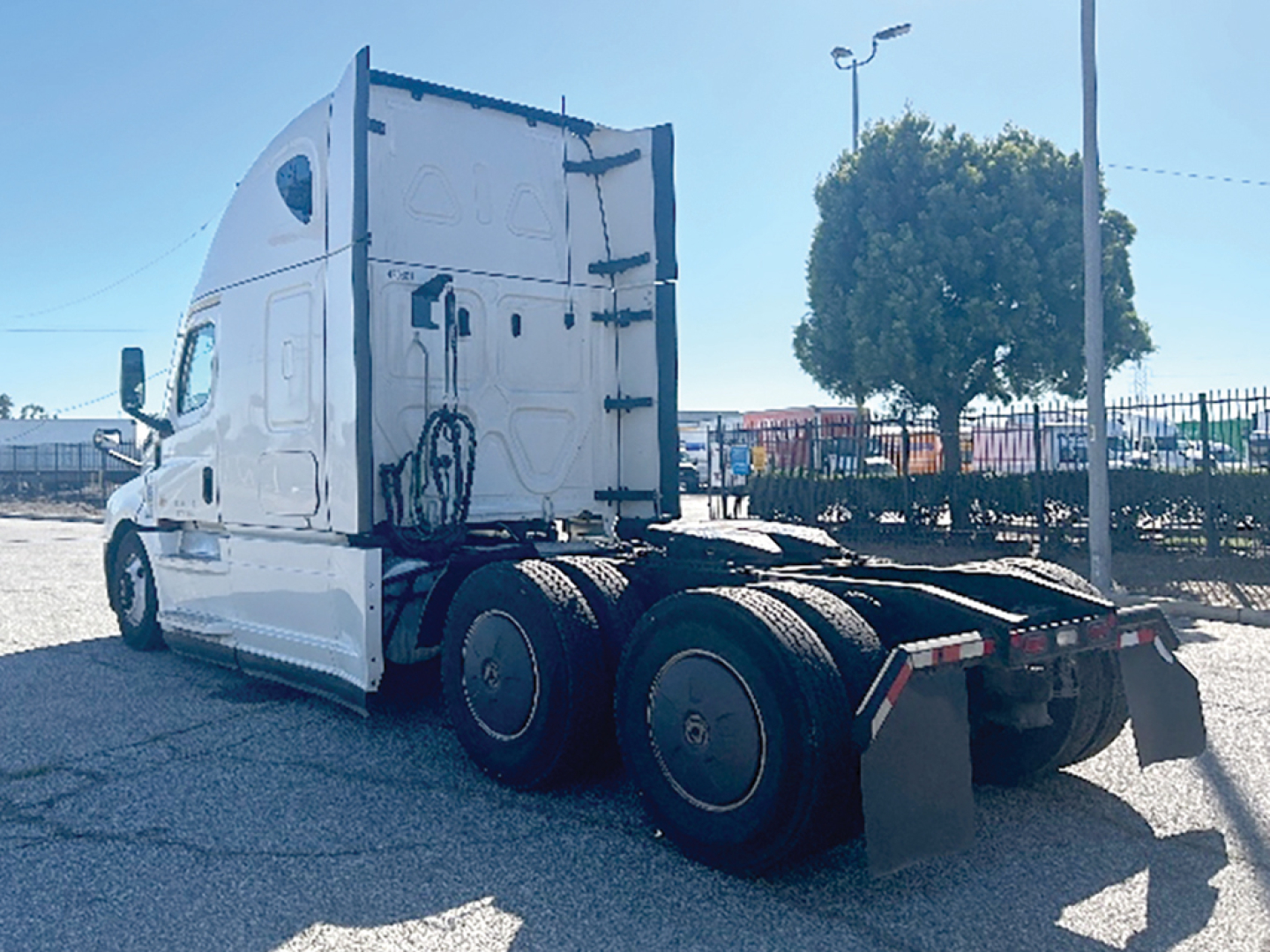 Freightliner Cascadia126 tractor-trailer chassis rear view showing dual rear axles and fifth wheel mount.