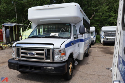 Ford E-350 wheelchair bus in-service showing front grille, headlights, and side blue stripe on white body.