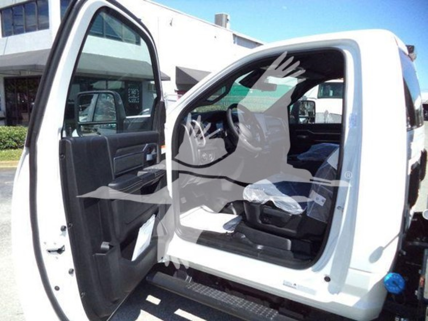 Ram pickup truck cab interior visible through open rear door; front seats and dashboard partially visible.