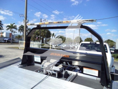 Truck bed with JERRDAN rollback system, visible winch hardware and mounting frame; top light bar on cab-arch; some orange text reading 'JERRDAN' on the rack.