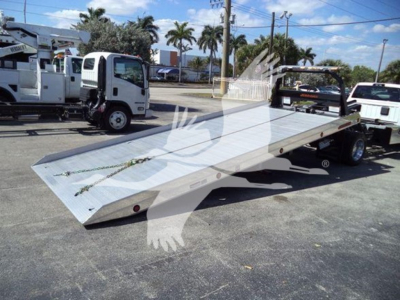 Truck bed tow rollback flatbed on Ram 2026 Big Horn chassis with dual rear wheels and aluminum ramped deck.
