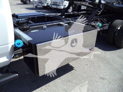Truck bed toolbox mounted on a Ram Big Horn chassis showing a large rectangular black toolbox with metal latches and a blue fluid cap visible on the side.