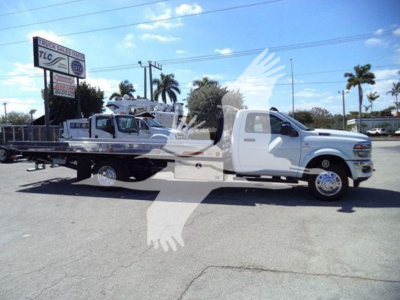 Ram heavy-duty tow truck with a flatbed, white color, side view showing cab and long flatbed attachment.