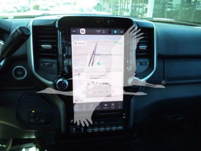Ram 2500/3500 interior dashboard with large vertical touchscreen; navigation map displayed; center console controls.