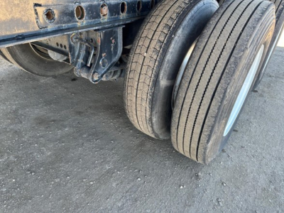 Trailer axle and dual rear tires of a Fontaine Velocity flatbed showing suspension and mounting brackets.