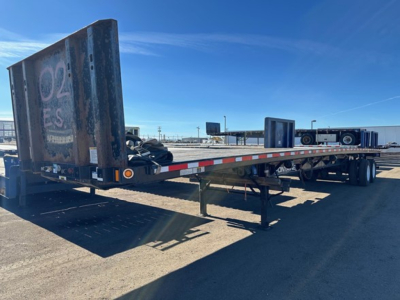 Flatbed trailer showing rear and side, with wooden deck and metal ramp, Fontaine Velocity 48' steel flatbed trailer in-service.