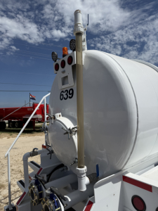 Tank trailer rear showing vertical exhaust/vent pipe, round manway, mounting hardware, rear lights, and the number 639 on the white cylindrical tank.