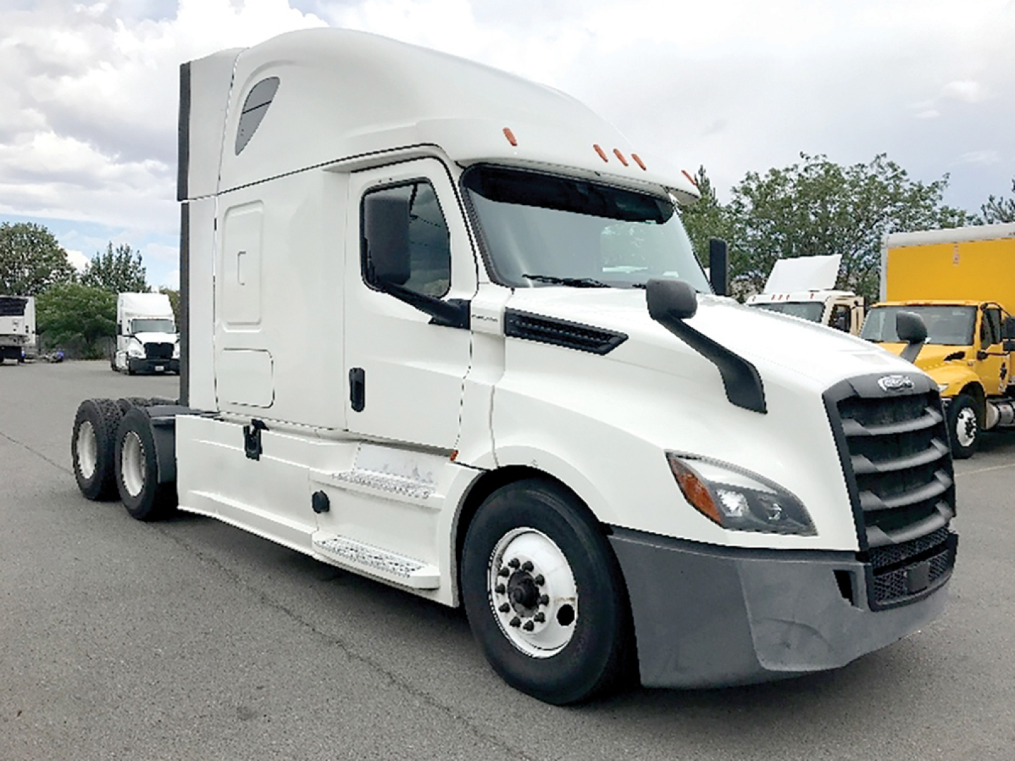 Freightliner Cascadia126 sleeper cab tractor showing front grille, headlights, and side fuel tanks with white paint and black bumper.