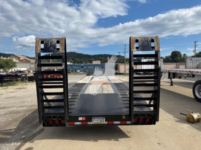 Rear view of a used Dorsey lowboy trailer with steel ramps and a flatbed, license plate PT-514XO, in a yard.