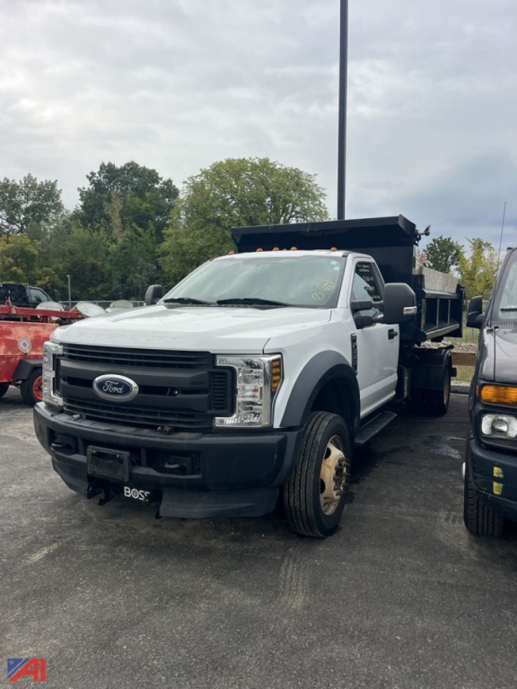 Ford F-550 dump truck in white with black front bumper and dump bed, shown from front-right angle, VIN 1FDUF5HY4KDA12022 visible in listing context.