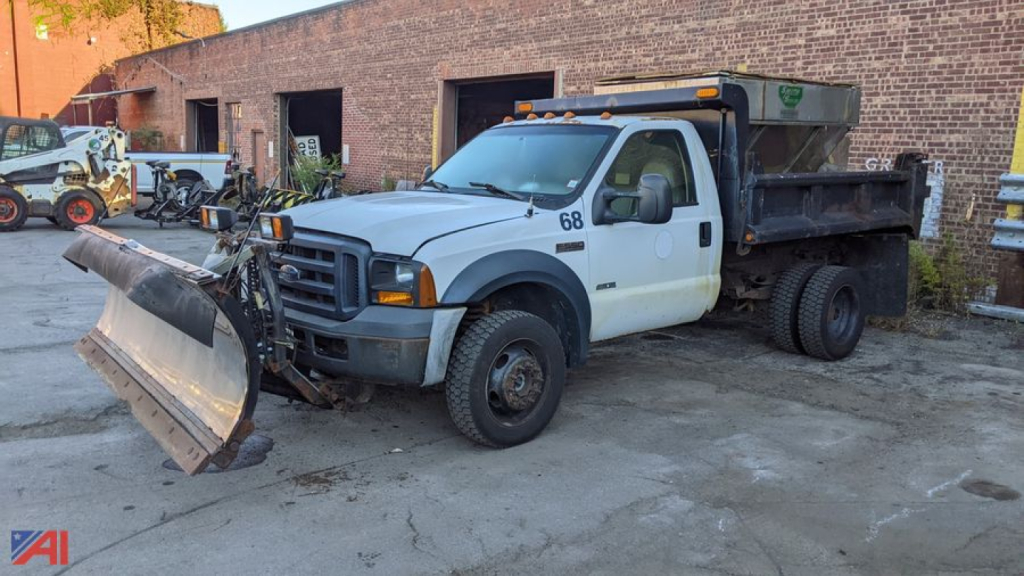 Ford F-550 Super Duty dump truck with plow and sander, white cab, black dump bed, snow plow and front mount blade attached, 68 decal on door, utility lights on roof, in-service condition.