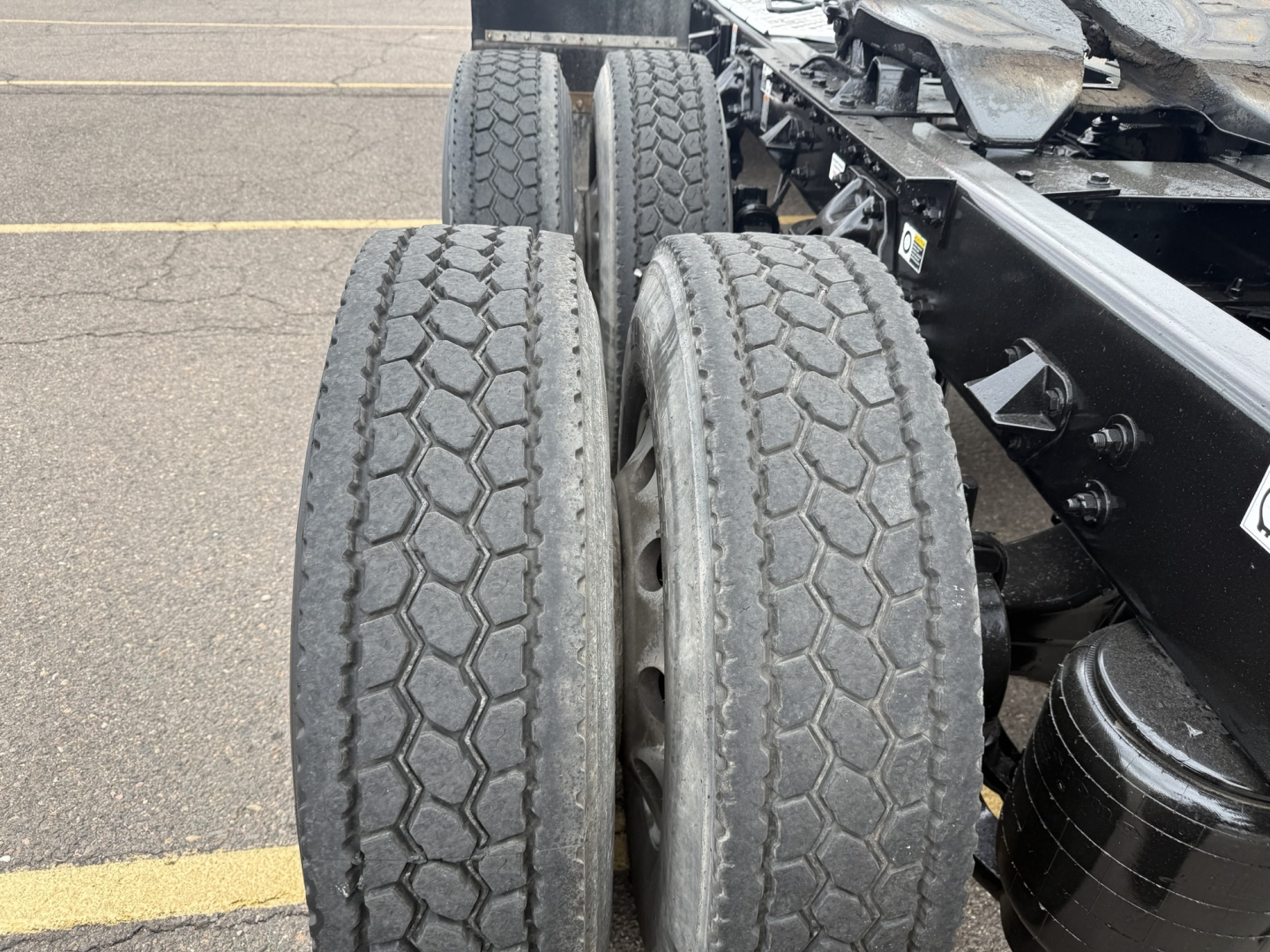 Kenworth T880 axle and dual rear tires showing tread and suspension components.