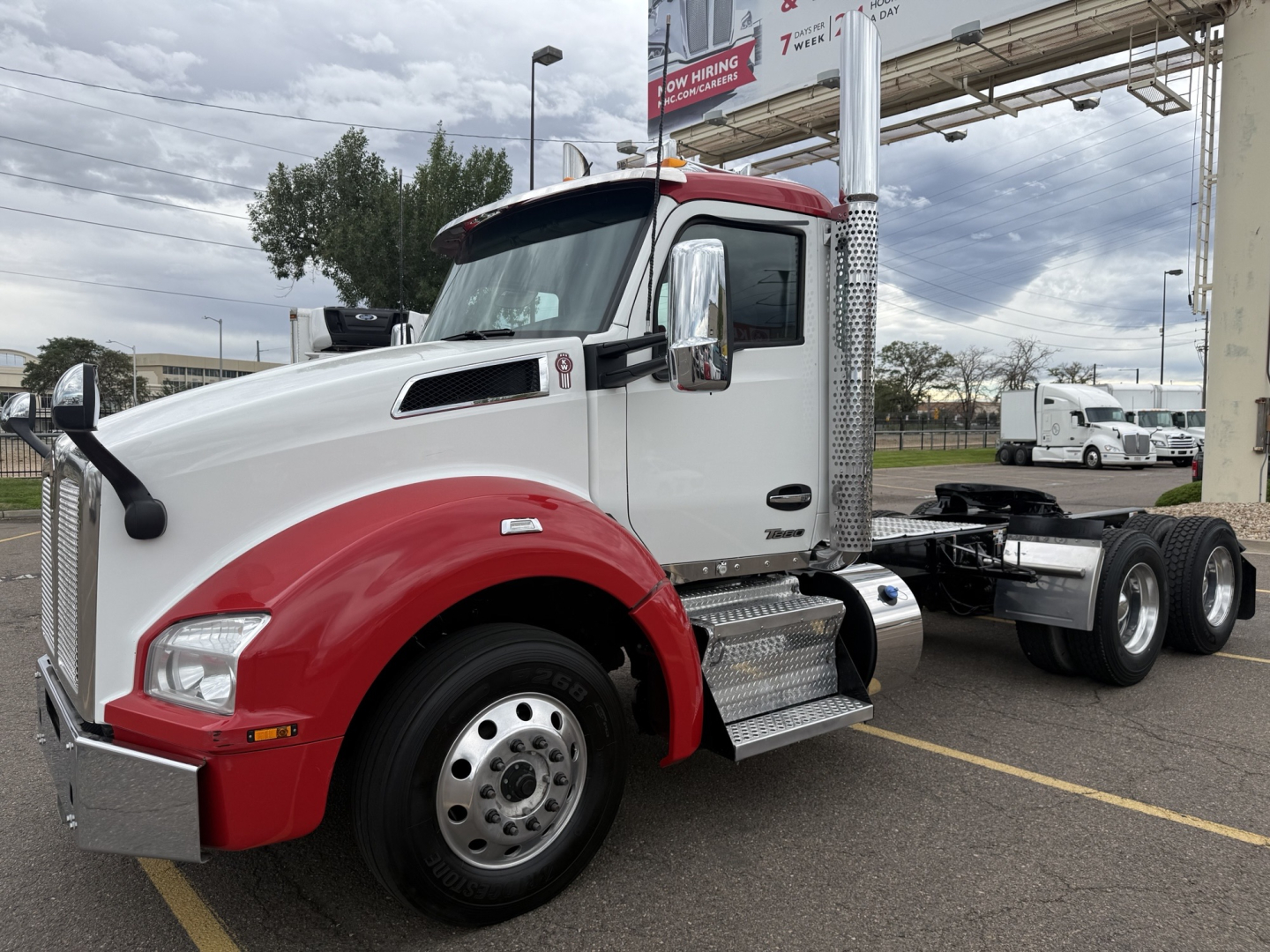 Kenworth T880 conventional daycab truck in white and red with chrome mirrors and steps, side view showing cab and chassis
